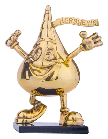 The Hershey’s Kiss character with arms raised, in 24-karat gold on a black base
