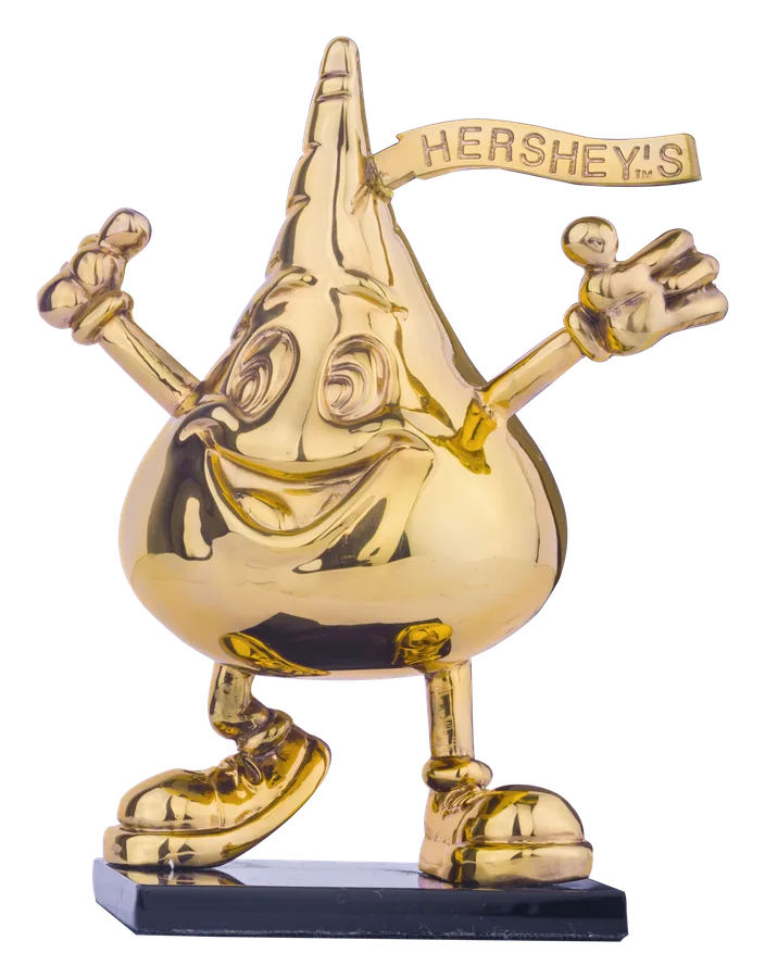 काले आधार पर 24 कैरेट सोने में उठे हाथों वाला Hershey’s Kiss पात्र