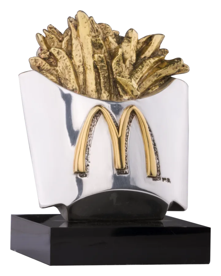 चाँदी के डिब्बे से निकलते 24 कैरेट सोने के McDonald’s फ़्रेंच फ़्राइज़, सोने के गोल्डन आर्चेज़ के साथ